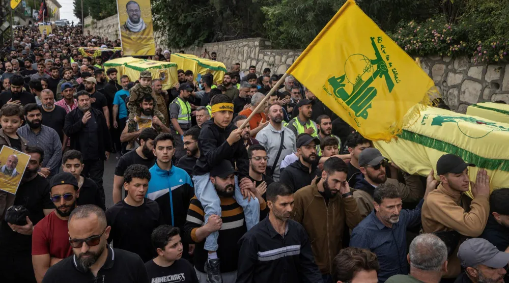 أعلام «حزب الله» خلال تشييع عدد من مقاتليه ومدنيين في جنوب لبنان (رويترز)