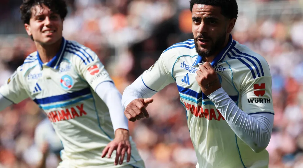 أندرو أوموباميديلي (يمين) يحتفل بهدف الفوز القاتل لستراسبورغ في مرمى لوريان (أ.ف.ب)