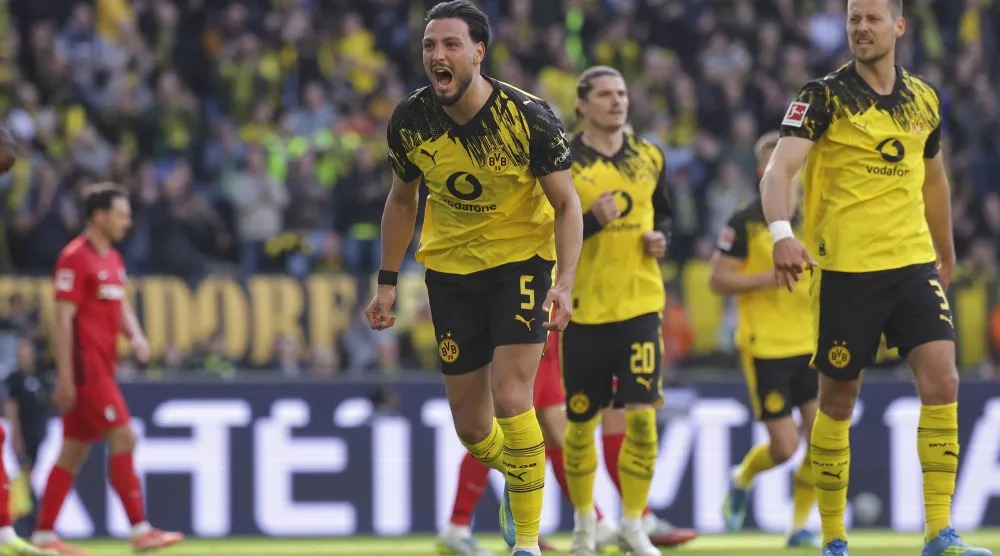 الجزائري الدولي رامي بنسبعيني يحتفل بفوز دورتموند (إ.ب.أ)