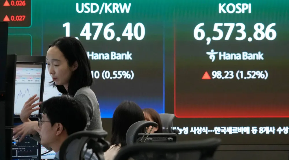 شاشة تعرض مؤشر «كوسبي» وسعر صرف العملات بين الدولار والوون  في غرفة تداول في سيول (أ.ب)