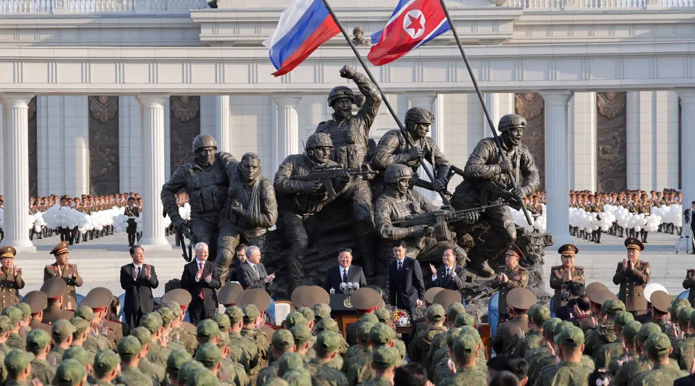 وزير الدفاع ورئيس البرلمان الروسيان يصفقان فيما يتحدث كيم جونغ أون خلال افتتاح المجمع التذكاري لتكريم الجنود الكوريين الشماليين الذين قتلوا في الحرب ضد أوكرانيا (وكالة الأنباء المركزية - رويترز)