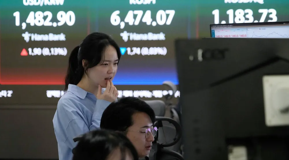 متداولو عملات يراقبون شاشات تعرض مؤشر «كوسبي» وسعر صرف الدولار/ الوون داخل بنك هانا في سيول (أ.ب)
