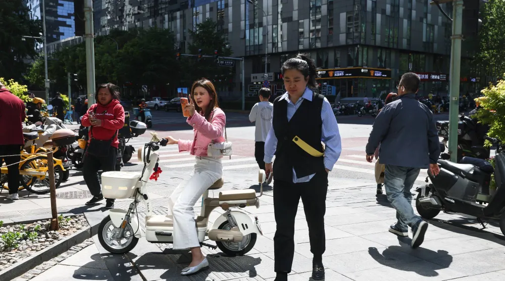 مشاة في الضاحية المالية بوسط العاصمة الصينية بكين (إ.ب.أ)