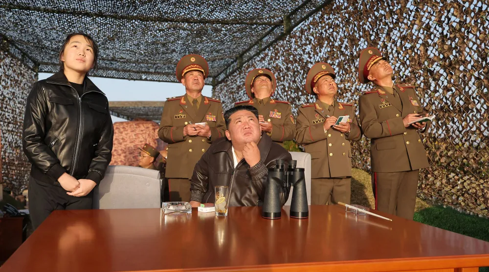 الزعيم الكوري الشمالي كيم جونغ أون (الوسط) وابنته كيم جو آي (اليسار) وهما يتفقدان تجربة إطلاق صاروخ باليستي في موقع لم يُكشف عنه في كوريا الشمالية (أ.ف.ب)