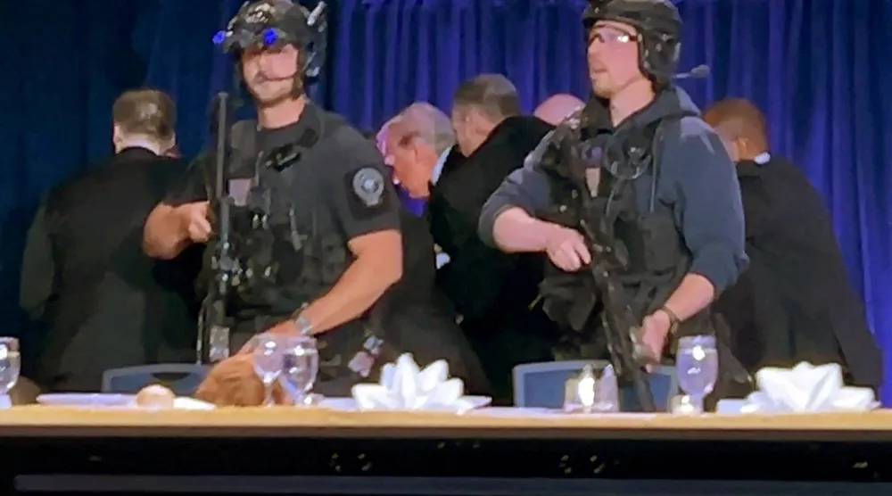 عناصر الشرطة والخدمة السرية يجلون الرئيس ترمب من صالة حفل «مراسلي البيت الأبيض» بعد إطلاق النار مساء السبت (رويترز)