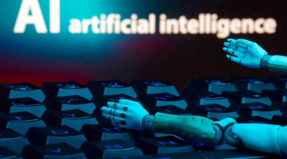 كلمة «الذكاء الاصطناعي» ولوحة مفاتيح ويدا روبوت في هذه الصورة التوضيحية (رويترز)