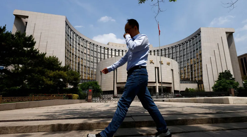 رجل يمر أمام مقر البنك المركزي في وسط العاصمة الصينية بكين (رويترز)