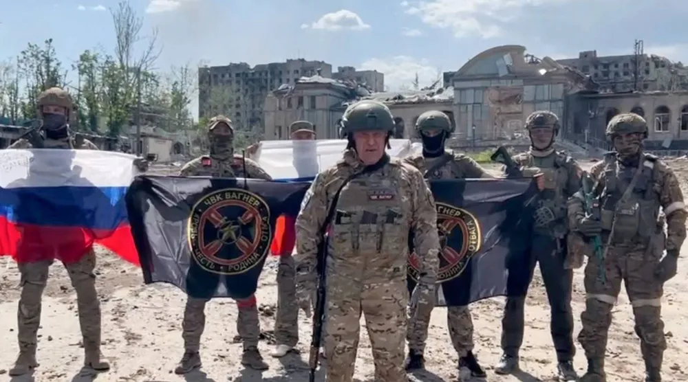 صورة من مقطع فيديو نُشر 20 مايو 2023 على «تلغرام» التابع للخدمة الصحافية لشركة «كونكورد» المرتبطة برئيس «فاغنر» يفغيني بريغوجين الذي يظهر واقفاً أمام عَلَم وطني روسي مع جنوده (أ.ف.ب)