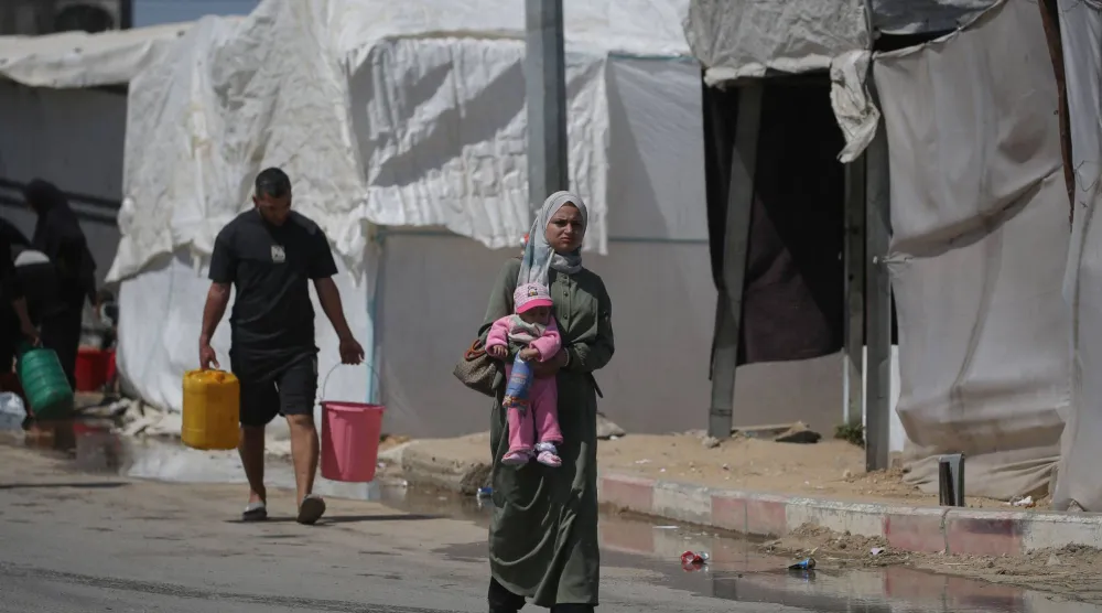 أشخاص يجلبون مياه الشرب في مخيم البريج للاجئين الفلسطينيين في وسط قطاع غزة 28 أبريل 2026 (أ.ف.ب)