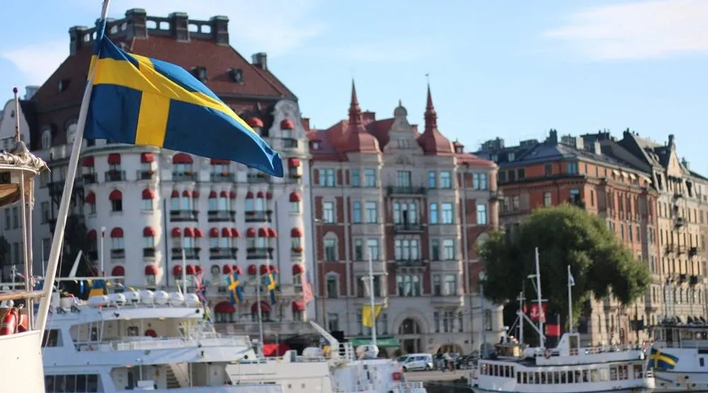 A Swedish flag flutters in front of residential houses in Stockholm, Sweden, September 14, 2023. (Reuters)