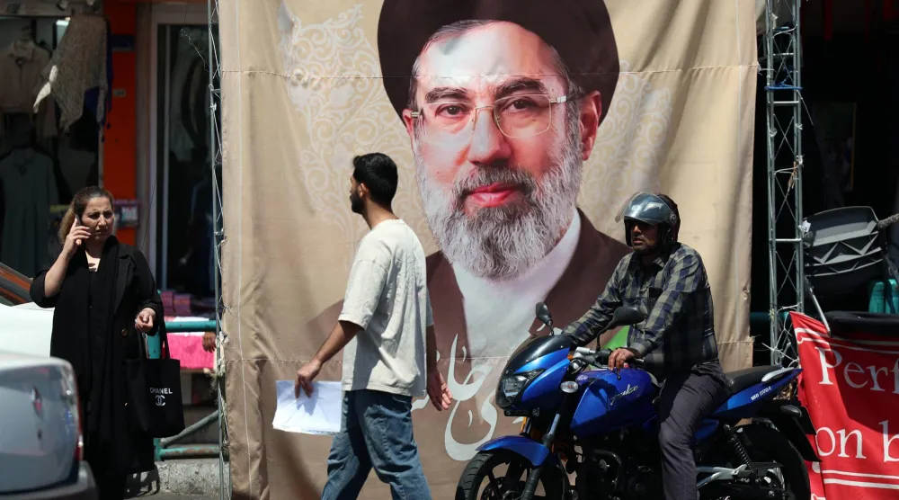 إيرانيون يمرون أمام ملصق للمرشد مجتبى خامنئي في طهران الثلاثاء (إ.ب.أ)