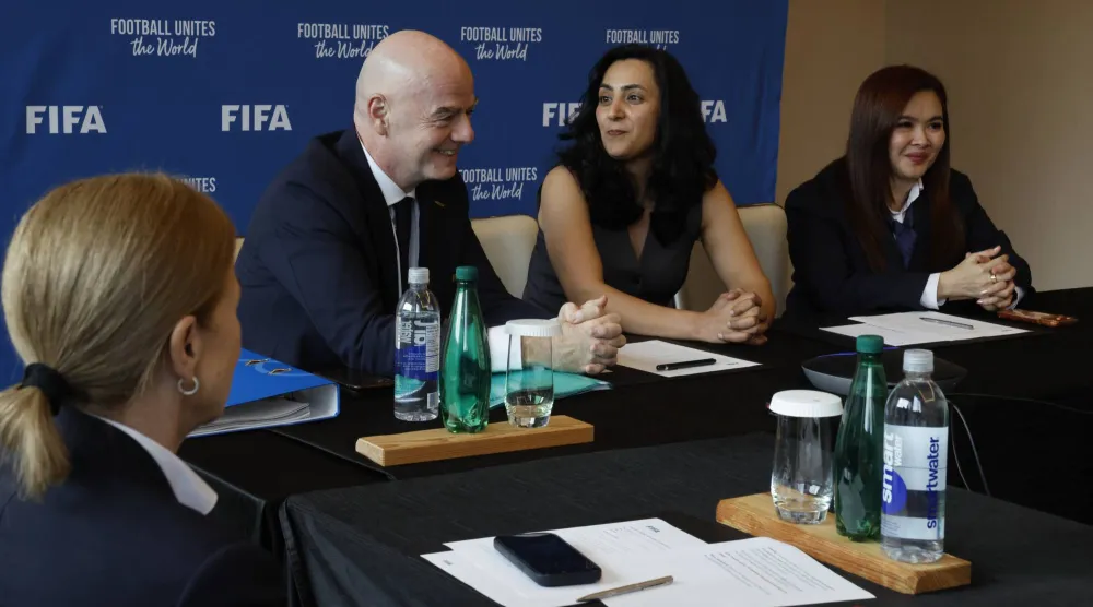 إنفانتينو ومديرة البرامج والفعاليات في منتخب أفغانستان للسيدات يحضران اجتماع «فيفا» مع فريق اللاجئات (د.ب.أ)