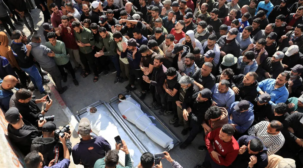 مشيّعون يحضرون جنازة فلسطينيين قُتلوا في غارة إسرائيلية وفق مُسعفين بمستشفى الشفاء بمدينة غزة (رويترز)