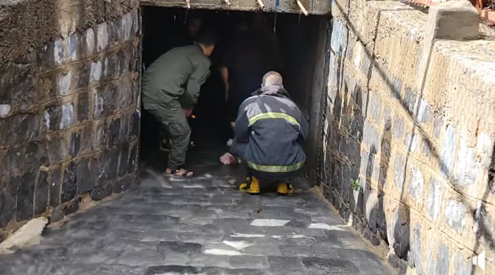 يمنيان من الدفاع المدني داخل قناة تصريف المياه يبحثان عن طفل جرفته السيول في تعز (إعلام محلي)