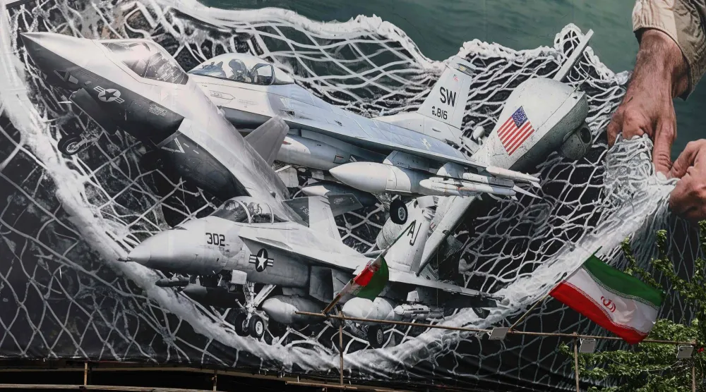  لافتة دعائية عملاقة تُظهر قوات إيرانية تستخدم شبكة لصيد طائرات مقاتلة أميركية، في ساحة انقلاب (الثورة) بطهران في 28 أبريل (أ.ف.ب)