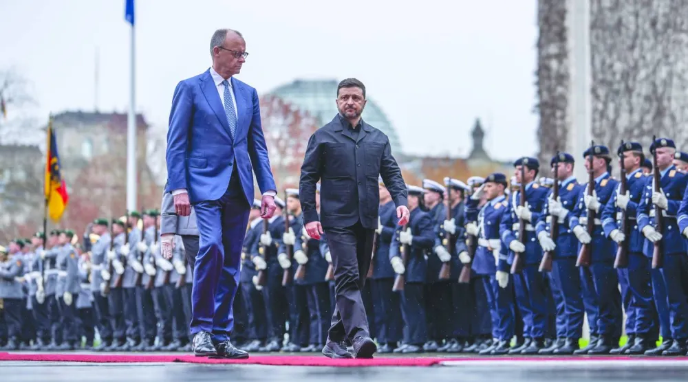 المستشار الألماني فريدريش ميرتس والرئيس الأوكراني فولوديمير زيلينسكي يستعرضان حرس الشرف أمام المستشارية الاتحادية في برلين أمس (د.ب.أ)