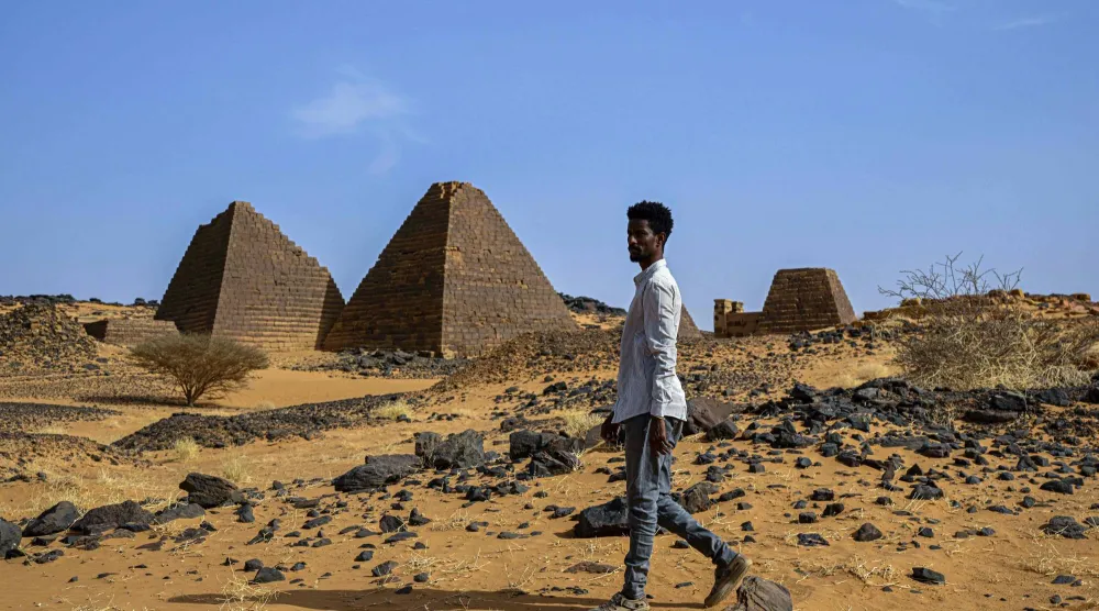عالم الآثار محمد مبارك بجوار الأهرامات القائمة في صحراء مروي - 22 أبريل 2026 (أ.ف.ب)