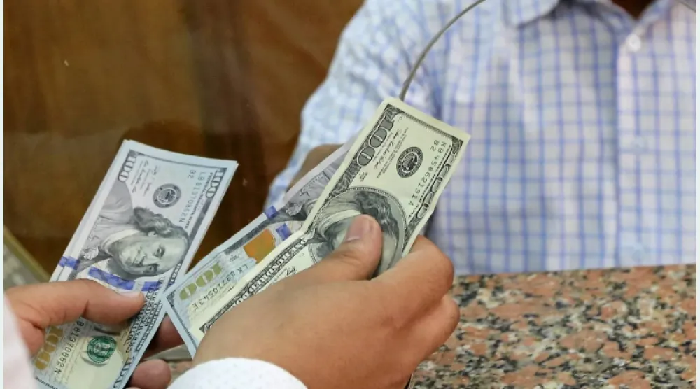 مواطن يستبدل دولارات من داخل مكتب صرافة في القاهرة (رويترز)