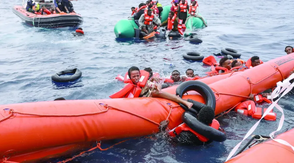 Libya kıyılarından Avrupa'ya doğru yola çıkan teknelerinin batmasının ardından kurtarılan göçmenler (AP)