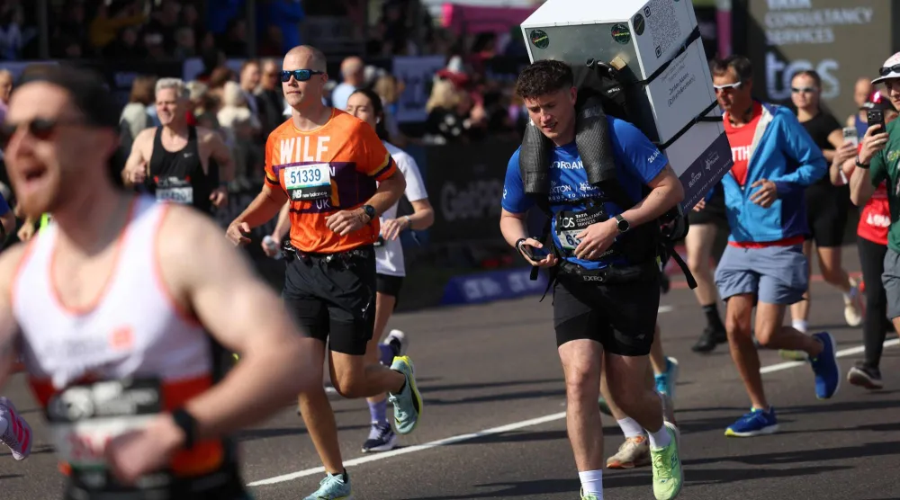 (FILES) British runner Jordan Adams carries a fridge at the start of the 2026 London Marathon at Blackheath in south-east London on April 26, 2026. (Photo by Toby Shepheard / AFP) 