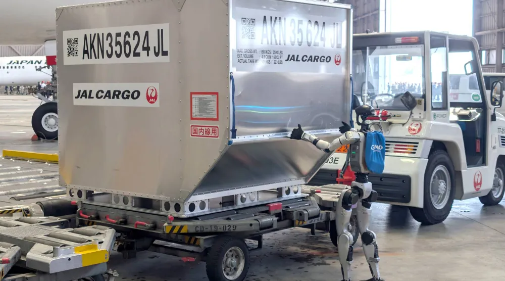 روبوت بشري الشكل يدفع حاوية خلال عرض إعلامي في مطار هانيدا بطوكيو (إ.ب.أ)