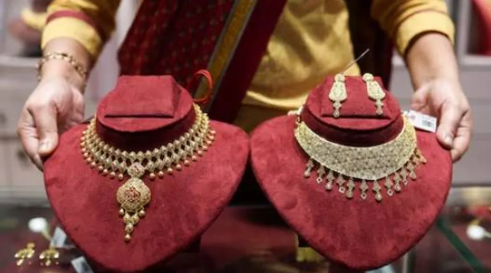 بائعة قلائد ذهبية داخل صالة عرض شركة «سينكو غولد آند دايموندز» للمجوهرات في كولكاتا بالهند (رويترز)