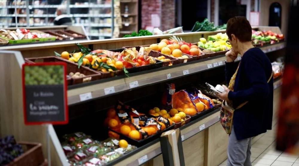 متسوقة بقسم الفواكه والخضراوات داخل أحد المتاجر الكبرى في شانفيري بفرنسا (رويترز)