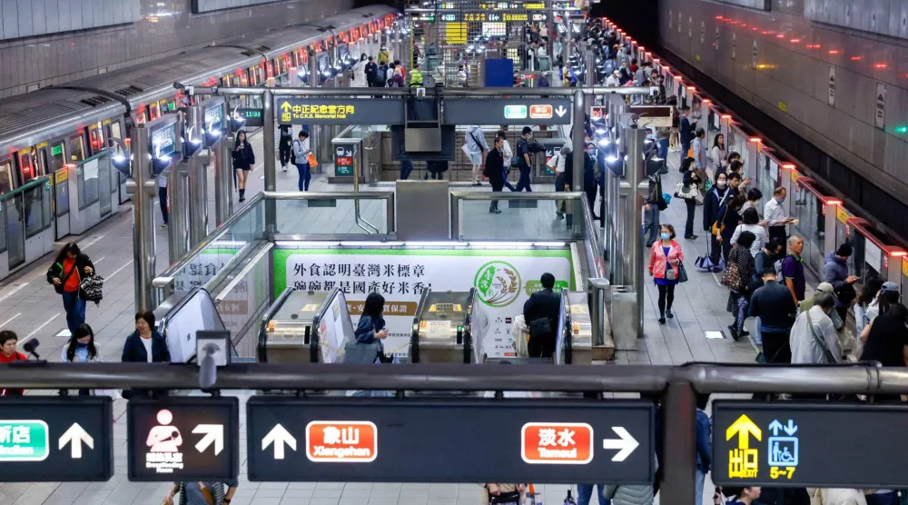 ركاب ينتظرون القطارات بمحطة مترو في تايبيه (رويترز)