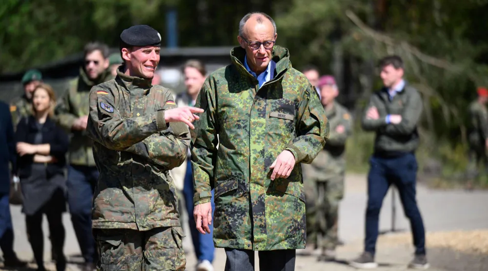 المستشار الألماني فريدريش ميرتس يرافقه مفتش الجيش كريستيان فرويدينغ خلال زيارة لثكنات الجيش الألماني بمونستر في شمال ألمانيا 30 أبريل 2026 (أ.ف.ب)