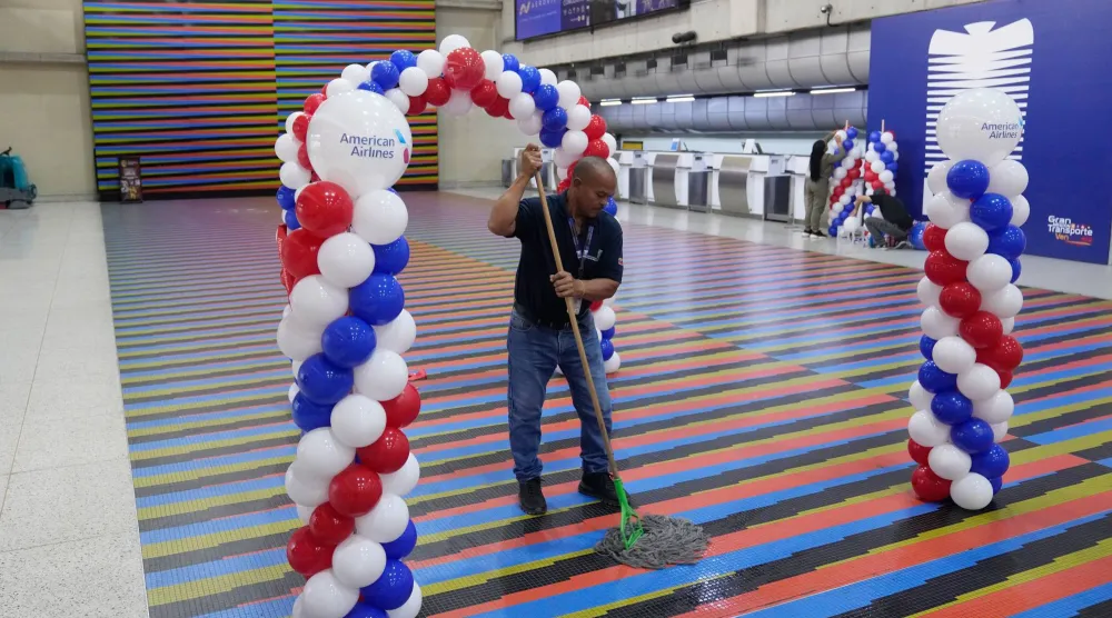 عامل ينظف أرض قاعة في «مطار سيمون بوليفار» بفنزويلا (أ.ب)