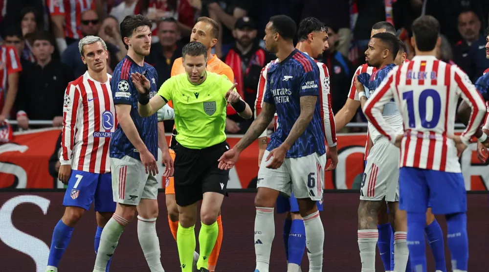 الحكم الهولندي داني ماكيلي يلجأ لتقنية الفيديو قبل إلغاء ركلة جزاء لأرسنال أمام اتلتيكو (رويترز)