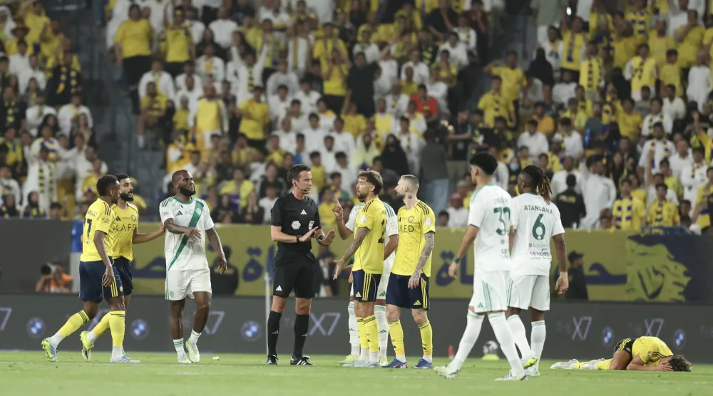 الحكم البلجيكي إيريك لامبرختس محاطا باللاعبينبعد إحدى القرارات (تصوير: عبدالعزيز النومان)