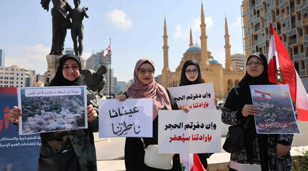 سكان من جنوب لبنان يحملون أسماء بلداتهم المحتلة والمعرضة للتدمير الإسرائيلي خلال اعتصام في ساحة الشهداء بوسط بيروت (أ.ف.ب)