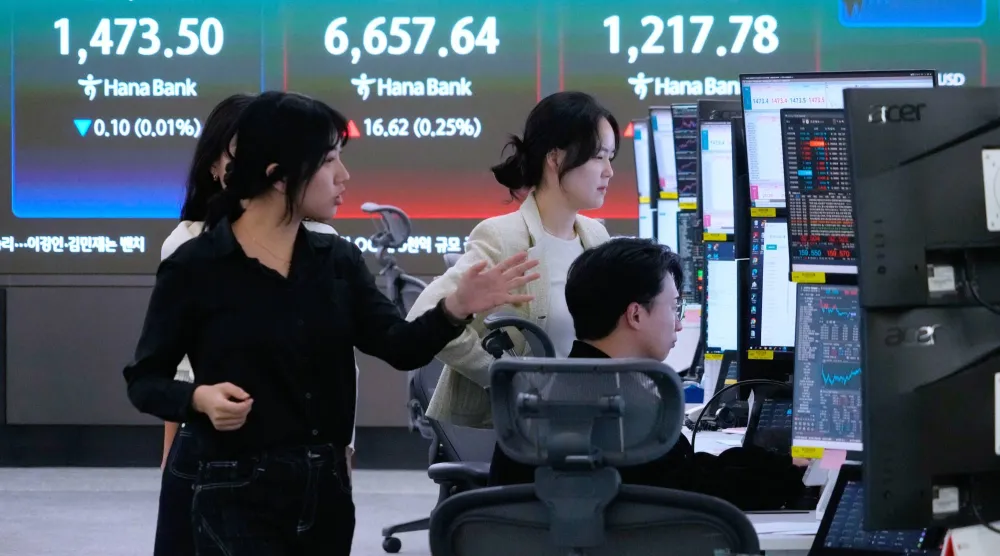 متداولو عملات يراقبون مؤشر «كوسبي» وسعر صرف الدولار مقابل الوون في بنك هانا بسيول (أ.ب)