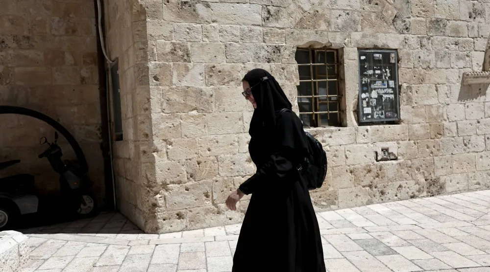 راهبة تمر بالقرب من البلدة القديمة في القدس (إ.ب.أ)
