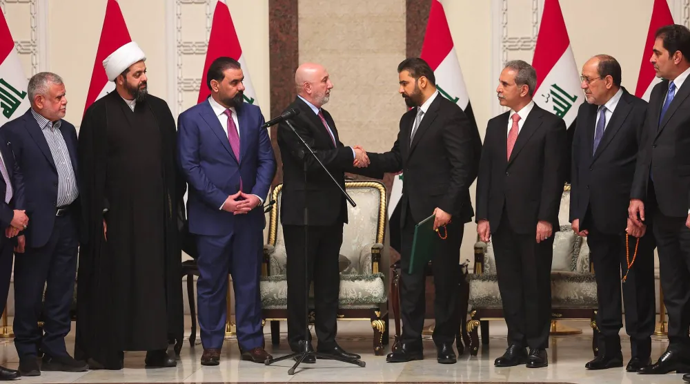 صورة نشرها المكتب الصحافي لرئاسة الجمهورية العراقية يوم 27 أبريل 2026 تظهر الرئيس العراقي نزار آميدي وهو يُصافح رئيس الوزراء العراقي الجديد علي الزيدي (أ.ف.ب)