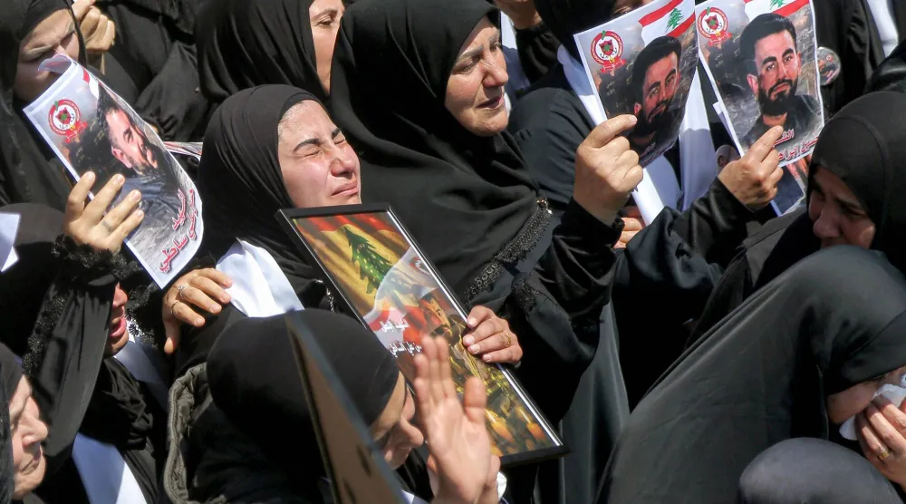 سيدات ينتحبن خلال موكب جنازة ثلاثة من أعضاء الدفاع المدني اللبناني الذين قُتلوا في غارة جوية إسرائيلية على قرية مجدل زون جنوب لبنان (د.ب.أ)