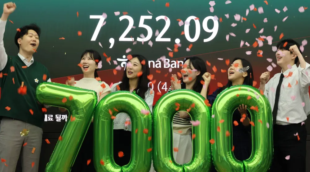 موظفون يحتفلون بتجاوز مؤشر «كوسبي» مستوى 7 آلاف نقطة لأول مرة في بنك هانا بسيول (إ.ب.أ)