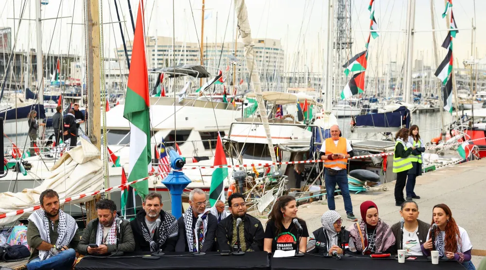 أعضاء اللجنة التوجيهية لـ«أسطول الصمود العالمي» ومنظمة «أوبن آرمز» يحضرون مؤتمراً صحافياً بينما يستعد الأسطول للمغادرة إلى غزة من برشلونة 12 أبريل 2026 (رويترز)