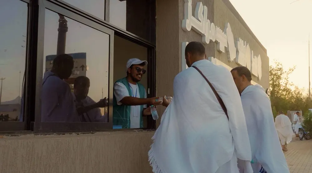 أحد مراكز «سقيا» تسلم حاجاً وجبة في مشعر مزدلفة (الشرق الأوسط)