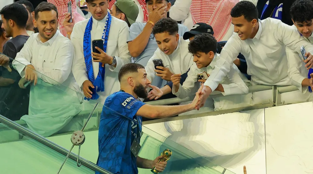جماهير الهلال تحيي بنزيمة بعد التتويج بكأس الملك (رويترز)