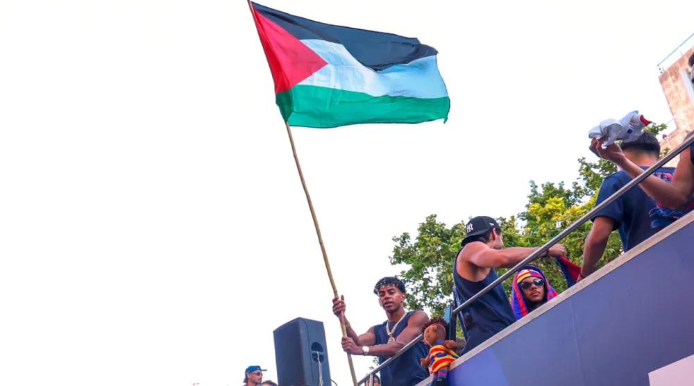 FC Barcelona player Lamine Yamal holds a Palestinian flag as he celebrates with his team atop a bus after winning the Spanish La Liga title in Barcelona, Spain, Monday, May 11, 2026. (AP Photo)