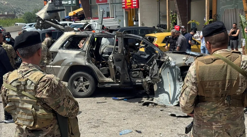عناصر من الجيش اللبناني في موقع استهداف إسرائيلي لسيارة بمنطقة الجية على أوتوستراد بيروت - الجنوب (رويترز)