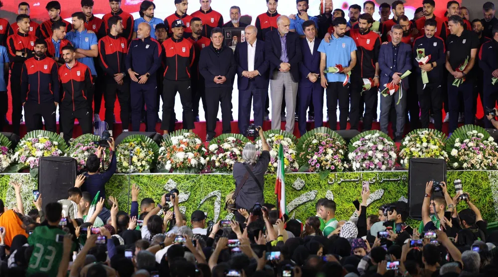 لاعبو المنتخب الإيراني على منصة التتويج خلال حفل وداع أقيم في طهران (إ.ب.أ)