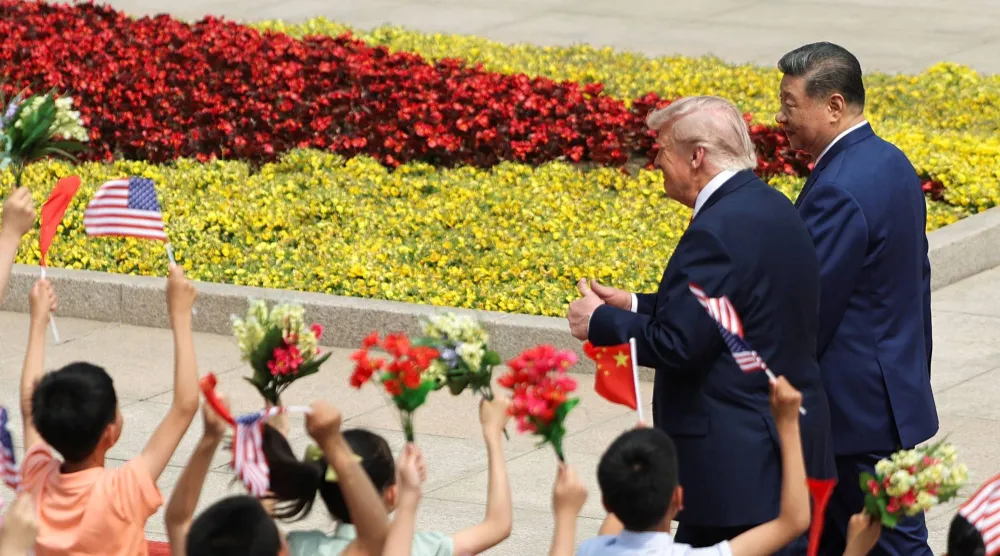 Children hold Chinese and US flags, as US President Donald Trump participates in a welcome ceremony with Chinese President Xi Jinping at the Great Hall of the People in Beijing, China, May 14, 2026. REUTERS/Maxim Shemetov/Pool