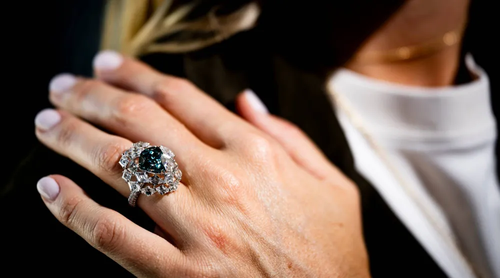 A Christie's employee displays "The Ocean Dream," the largest fancy vivid blue-green diamond, weighting 5.50 carats, during a preview at Christie's in Geneva, Switzerland, Thursday, May 7, 2026. (Jean-Christophe Bott/Keystone via AP)