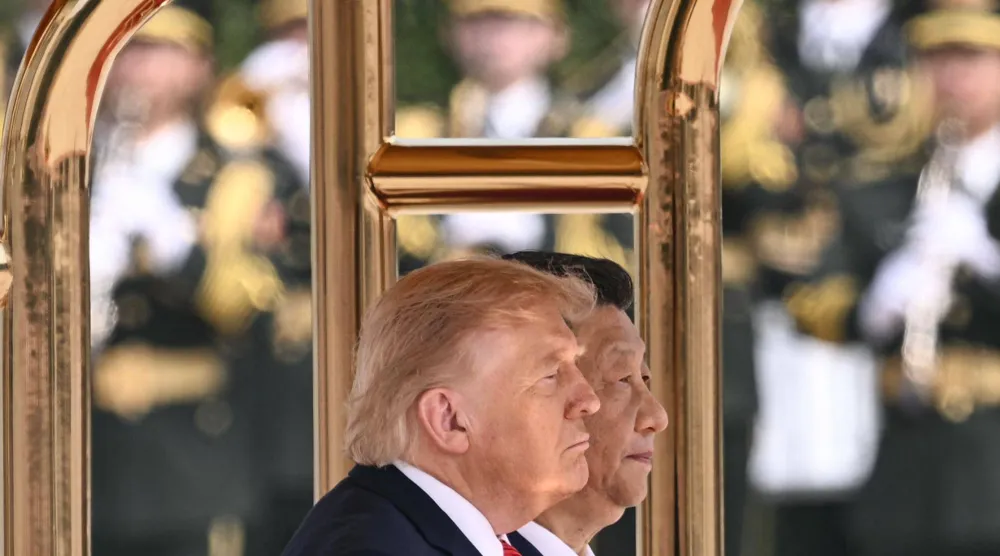 الرئيس الأميركي دونالد ترامب ونظيره الصيني شي جينبينغ يقفان أثناء عزف النشيدين الوطنيين لبلديهما خلال حفل استقبال في قاعة الشعب الكبرى في بكين (أ.ف.ب)