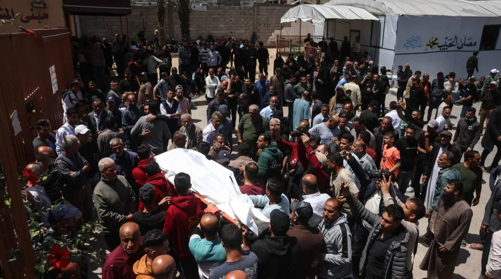 فلسطينيون يحملون جثمان قتيل استهدفته غارة جوية إسرائيلية وذلك خلال جنازته بمستشفى ناصر بخان يونس جنوب قطاع غزة في 10 مايو 2026 (أ.ف.ب)
