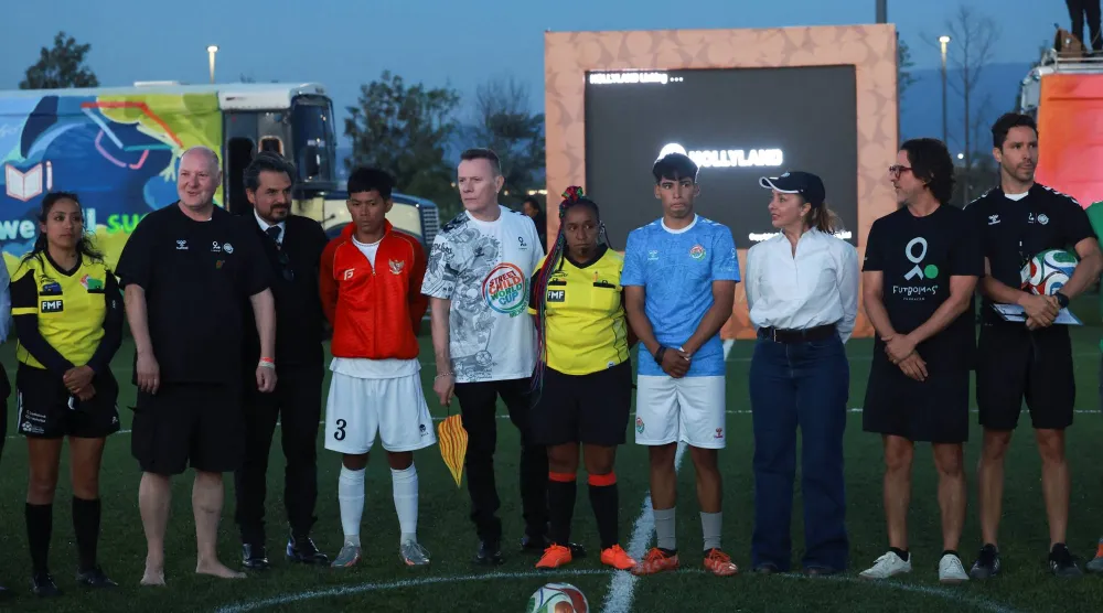 لاري مولين جونيور من فرقة «يو تو» مع لاعبي إندونيسيا والأرجنتين (رويترز)