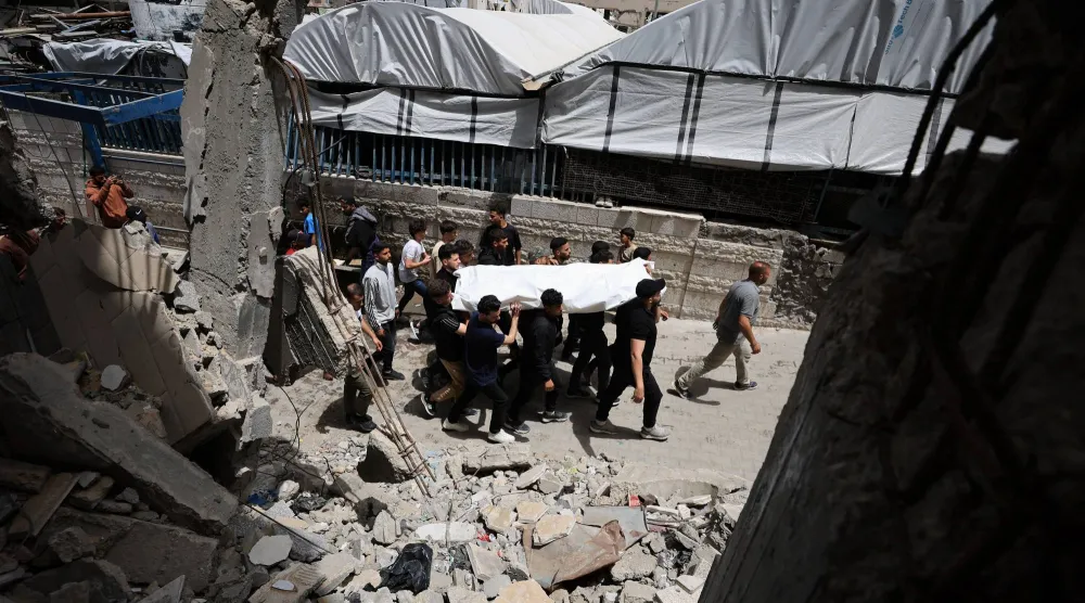 مشيعون يحملون جثماناً خلال جنازة فلسطينيين قُتلوا في غارة إسرائيلية على مدينة غزة (رويترز)